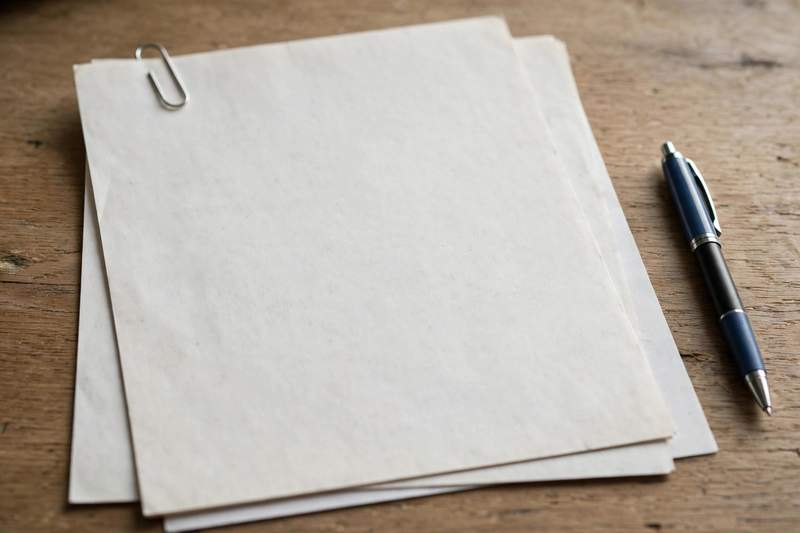 Lease document with an attached addendum page held by a paperclip and a pen on a desk